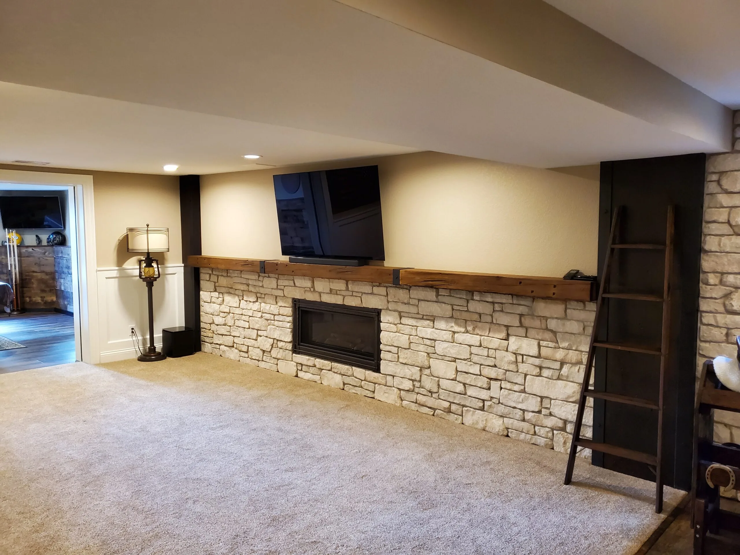 Basement lounge with stone fireplace