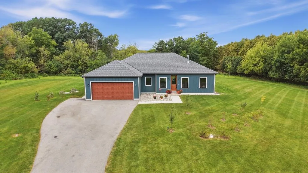 Blue-sided custom ranch home with landscaped yard