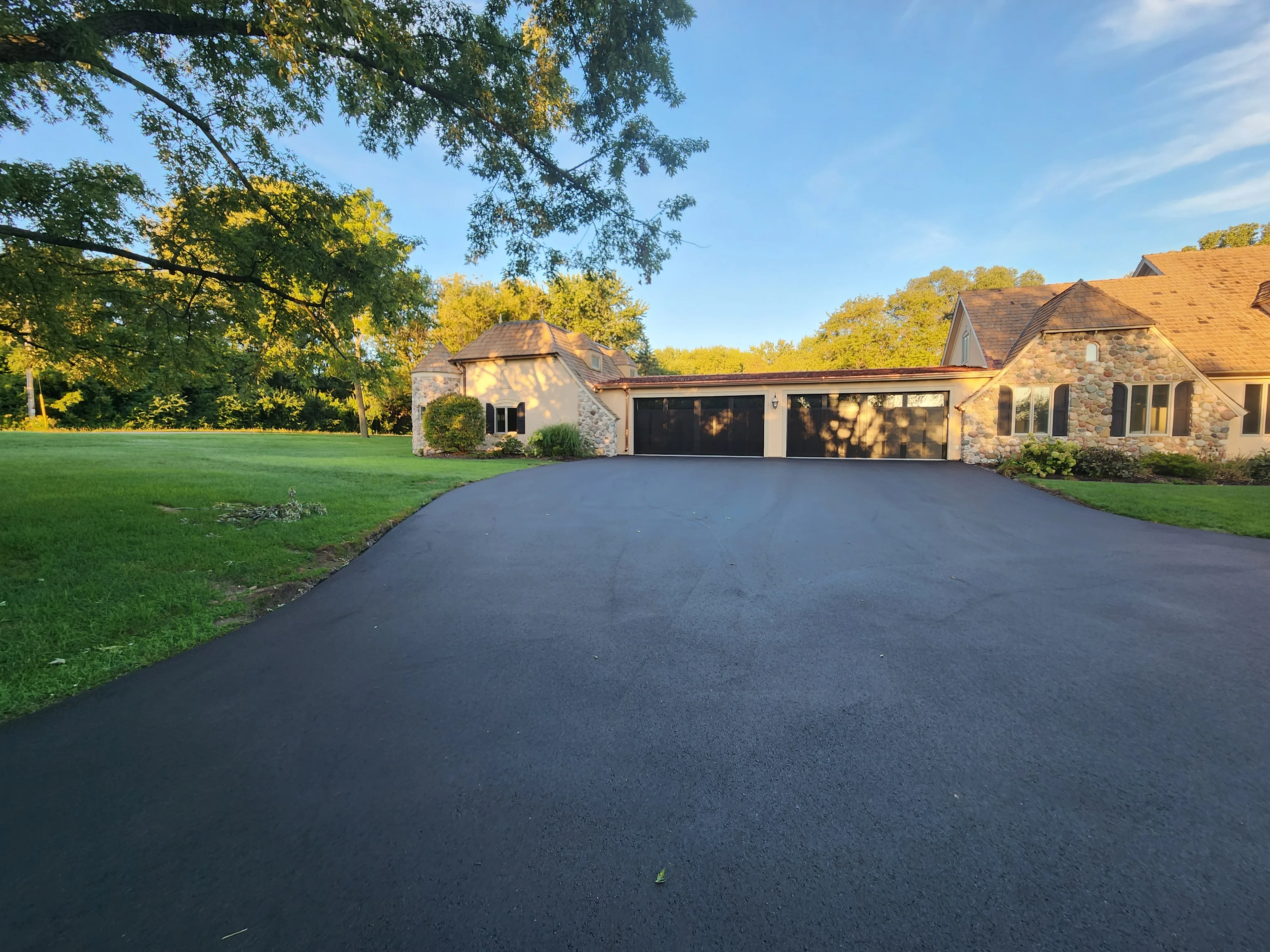 Stone and stucco custom home exterior with multi-car garage