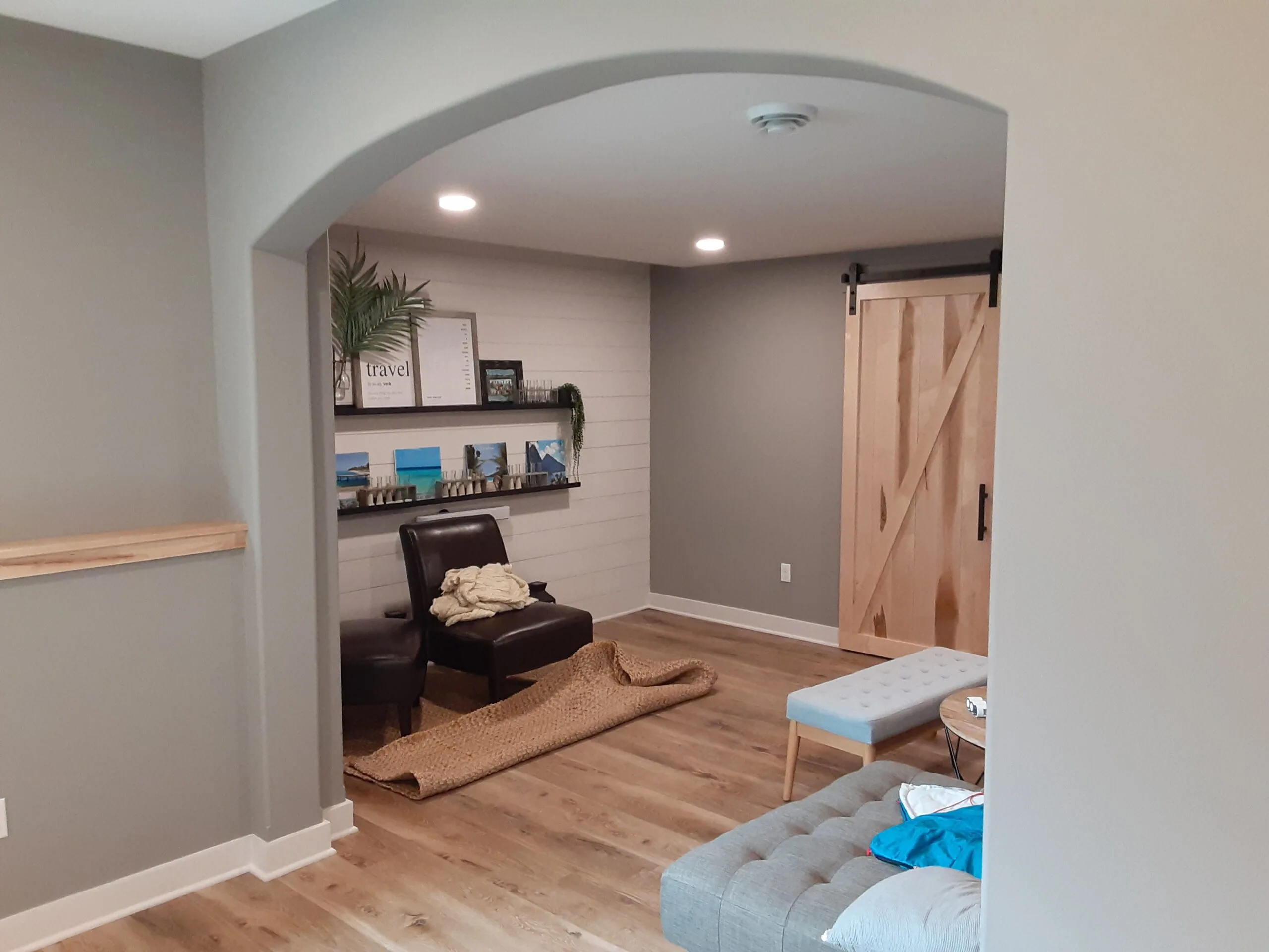 Finished residential living room with barn door and built-in shelving