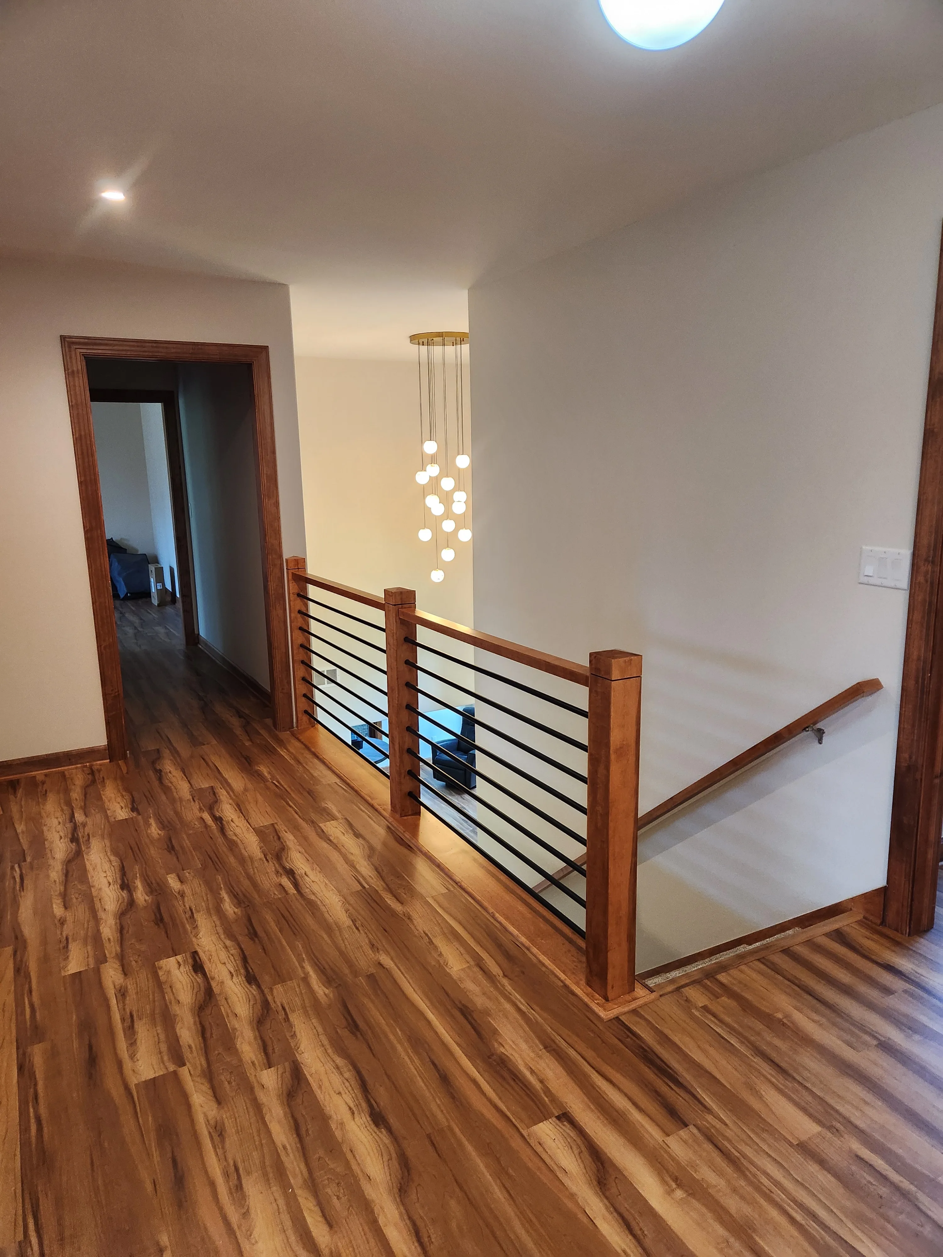 Residential staircase with walnut railings and black metal balusters